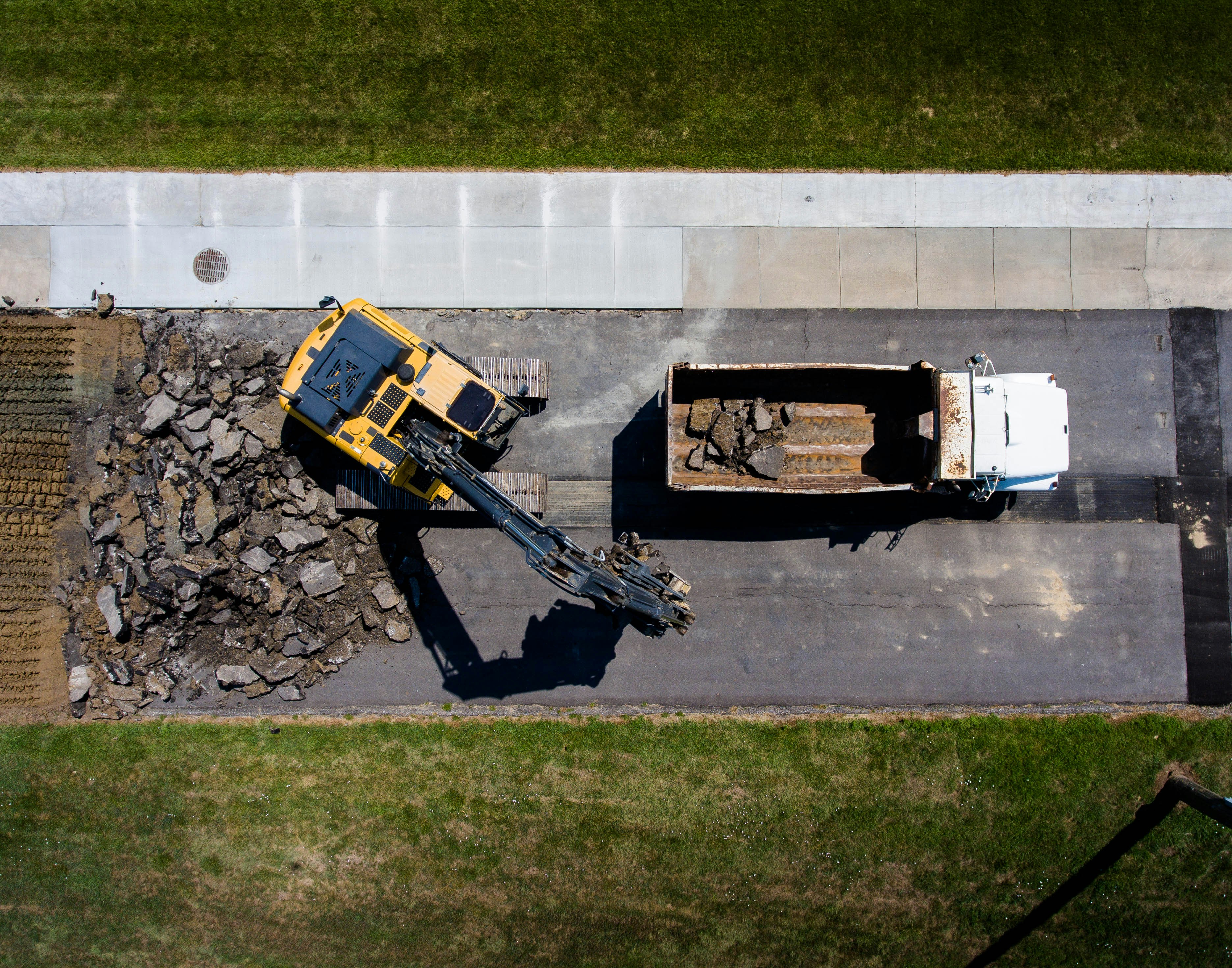 Loader filling a dump truck with aggregate at a construction yard