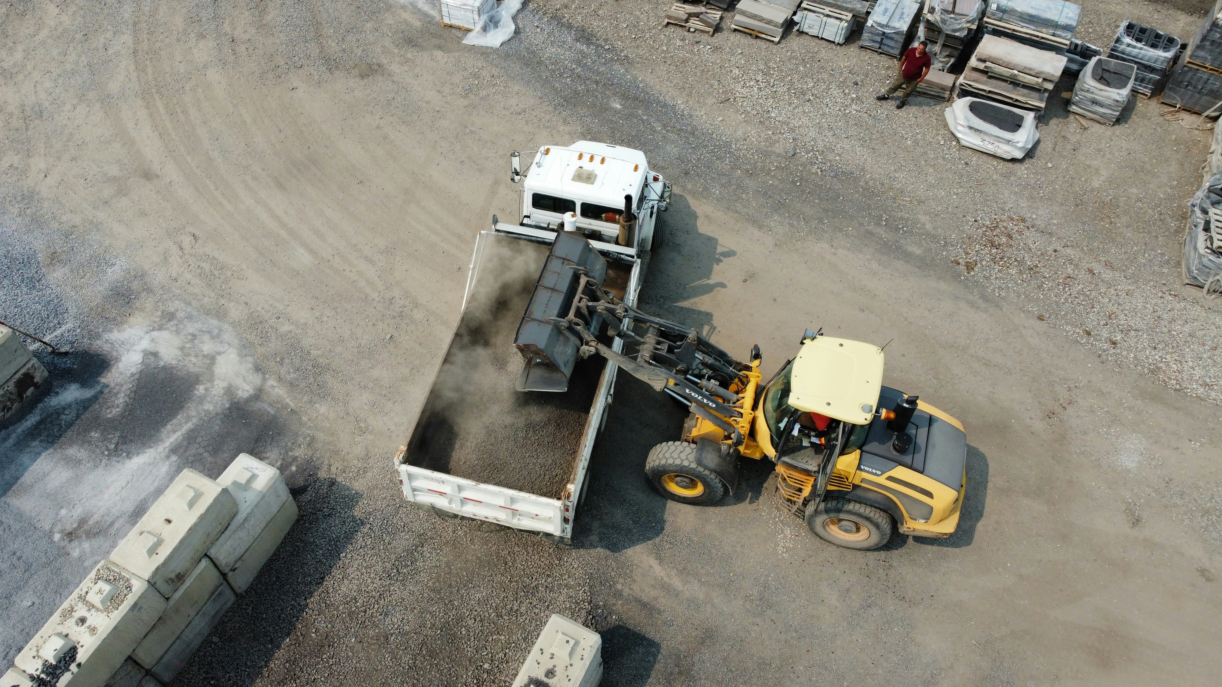 Aerial view of a dump truck and excavator on a construction and road work site